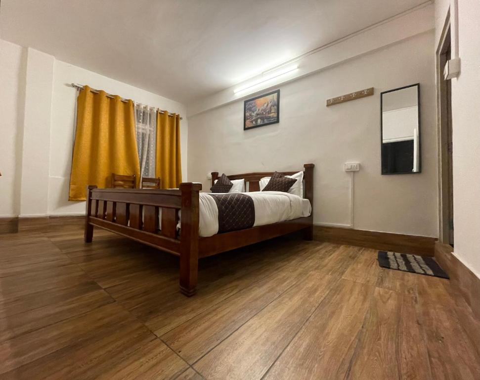 a bedroom with a bed and a wooden floor at HOTEL WHITE LOTUS in Darjeeling