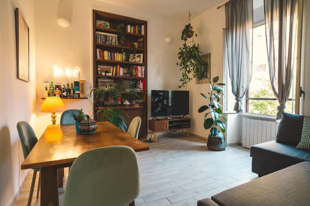 a living room with a dining table and a tv at Vaticano/Trastevere Floreal Suite in Rome