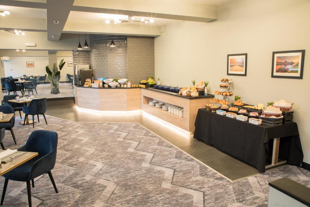a restaurant with a counter and a table with food at Park Inn by Radisson Bournemouth in Bournemouth