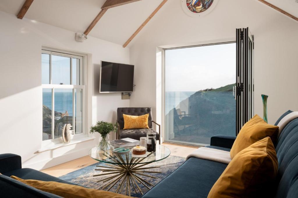 a living room with a couch and a glass table at Blue Horizon in Portloe