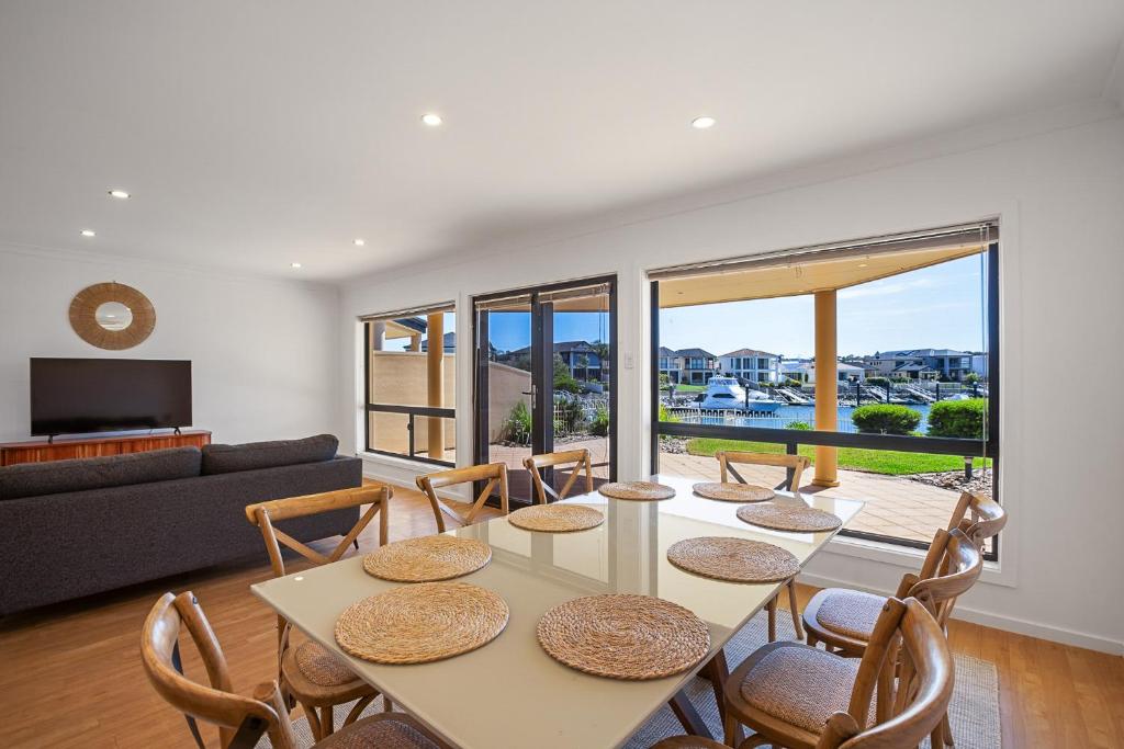 a living room with a table and chairs at Waterfront Villa Provence in Port Lincoln