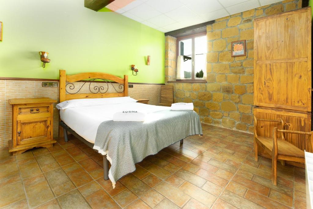 a bedroom with a bed and a table in it at BARRUTI LANDARBIDE - Para desconectar en plena naturaleza in Aia