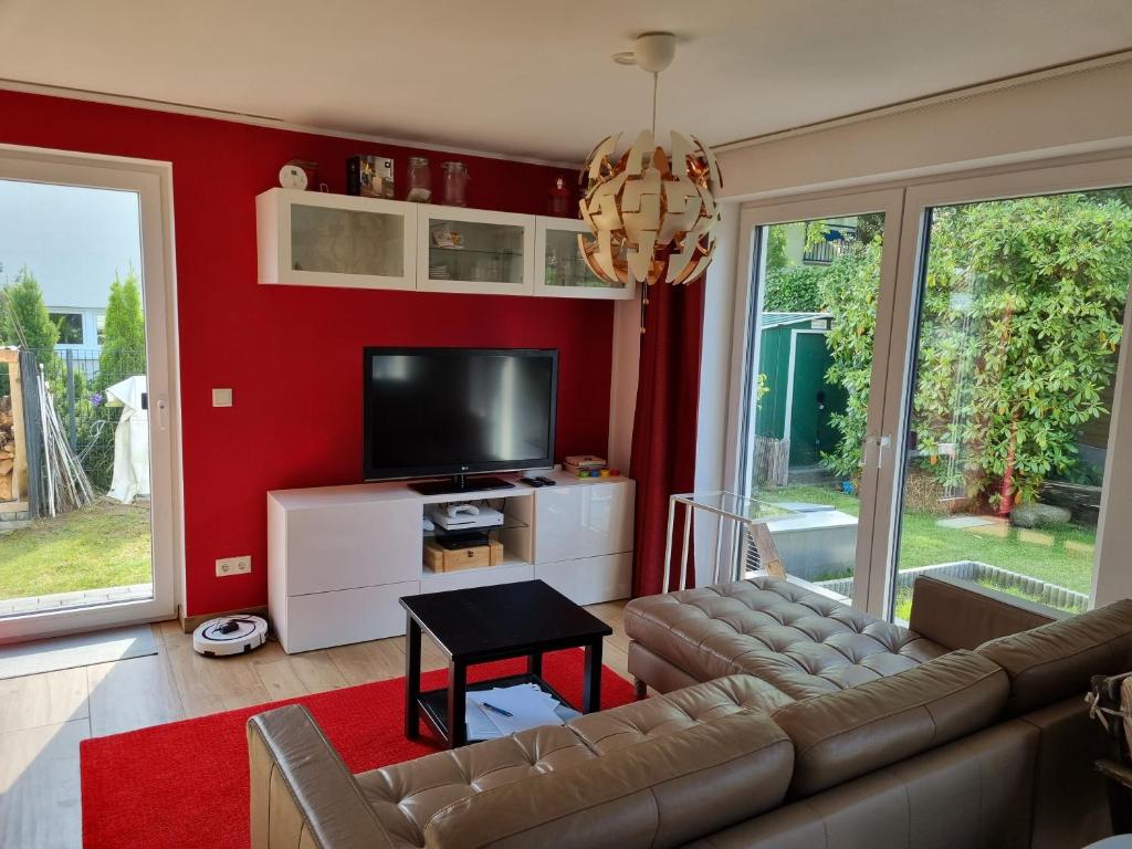 a living room with a couch and a flat screen tv at Ferienhaus Bojenweg in Rostock
