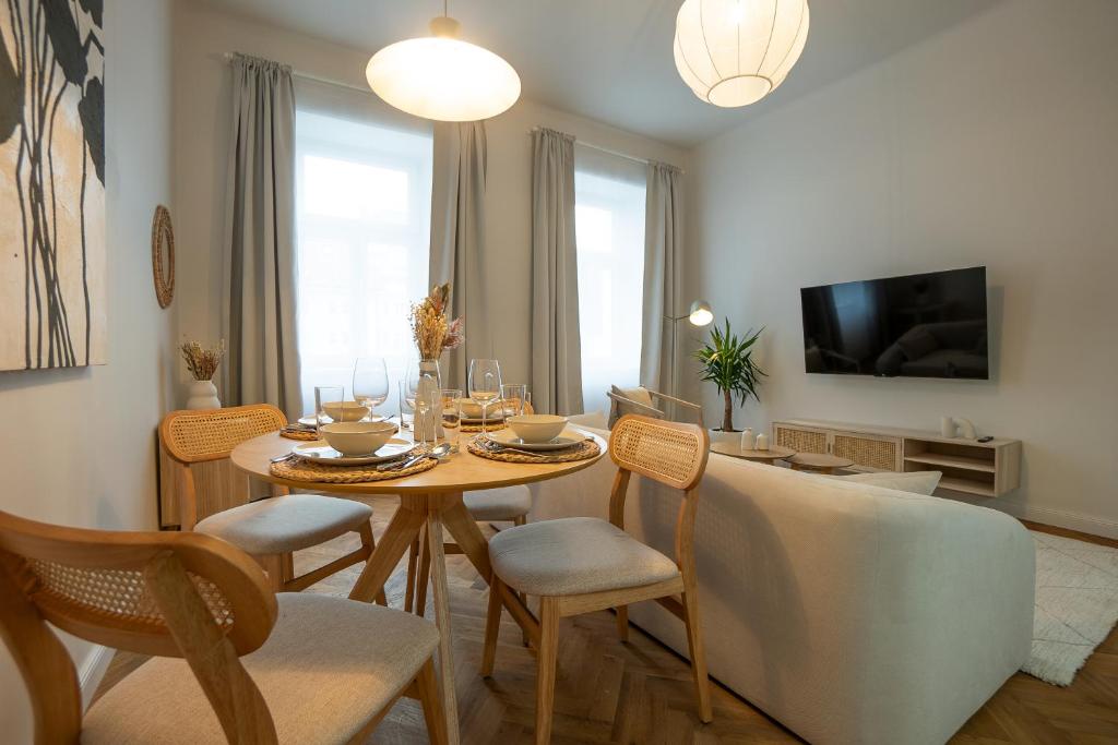 uma sala de estar com uma mesa e cadeiras e uma televisão em Brand-new 2-room apartment in a top location em Viena