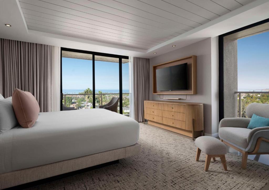a hotel room with a bed and a television at Hotel La Jolla, Curio Collection by Hilton in San Diego