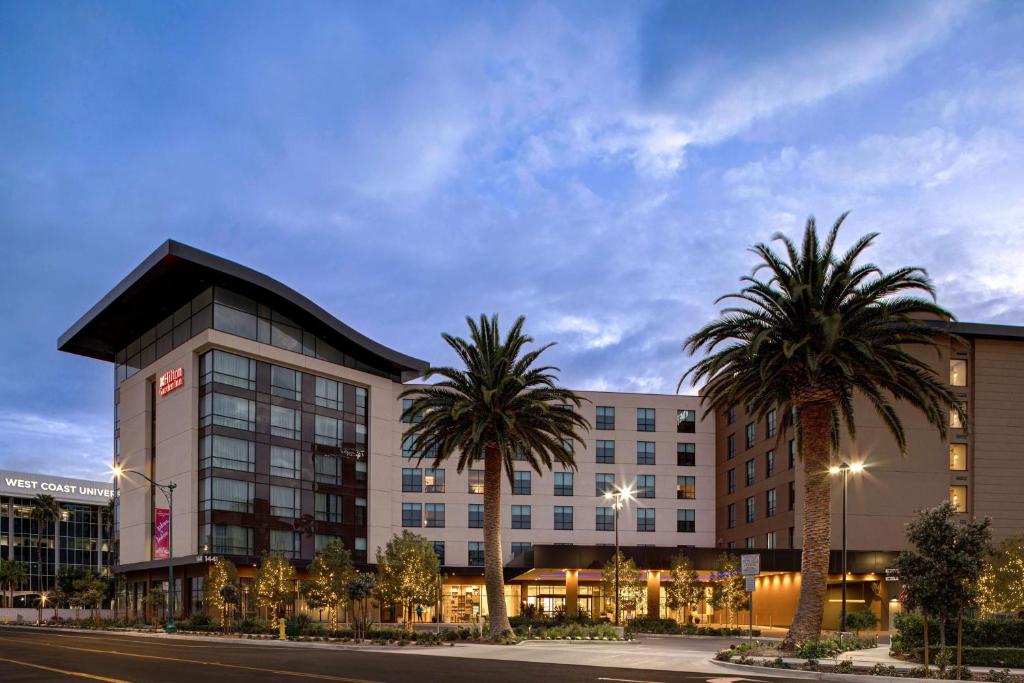 a hotel with palm trees in front of a building at Home2 Suites By Hilton Anaheim Resort in Anaheim