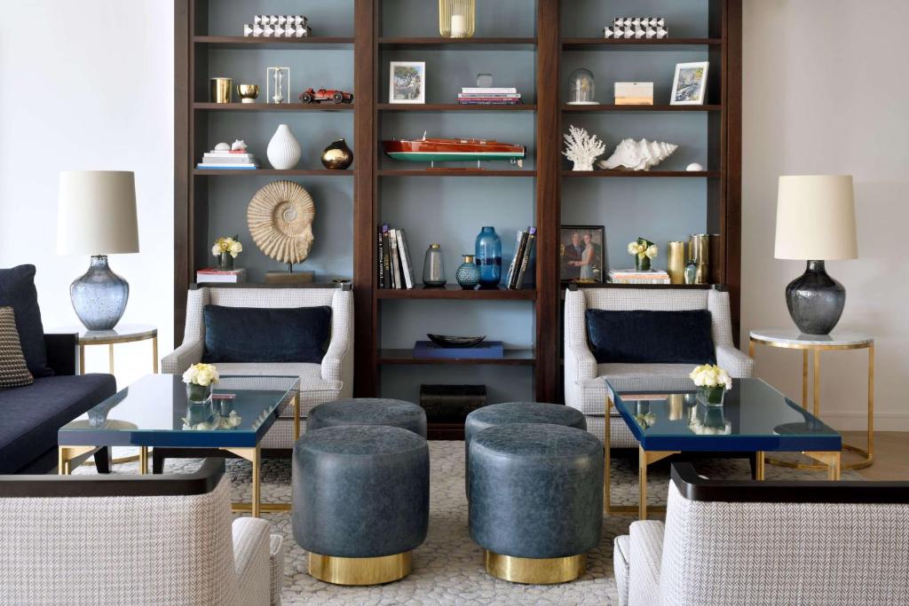 a living room with couches and tables and shelves at Columbus Hotel Monte-Carlo, Curio Collection by Hilton in Monte Carlo