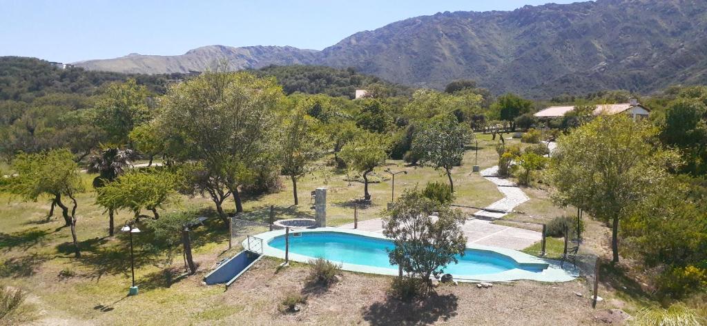 una vista aérea de una piscina con árboles y montañas en Hostería Las Lomas en Cortaderas