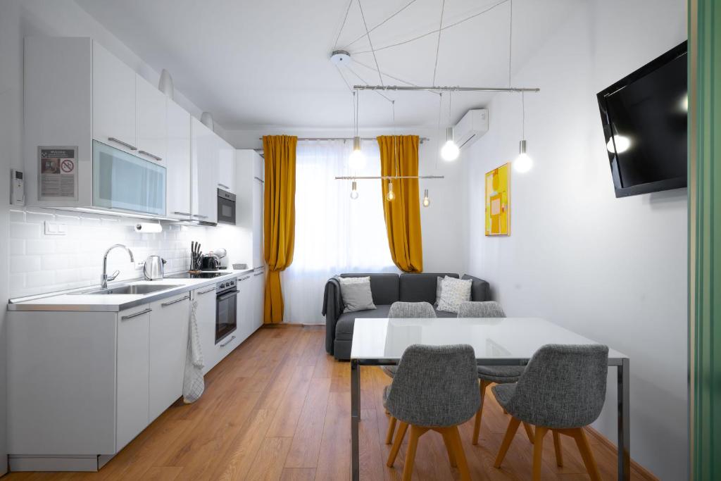 a kitchen and a living room with a table and chairs at Modern 2BD Flat with Prime Location and Workspace in Sofia