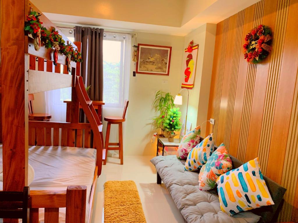 a living room with a couch with pillows on it at Cozynest Condotel Baguio in Baguio