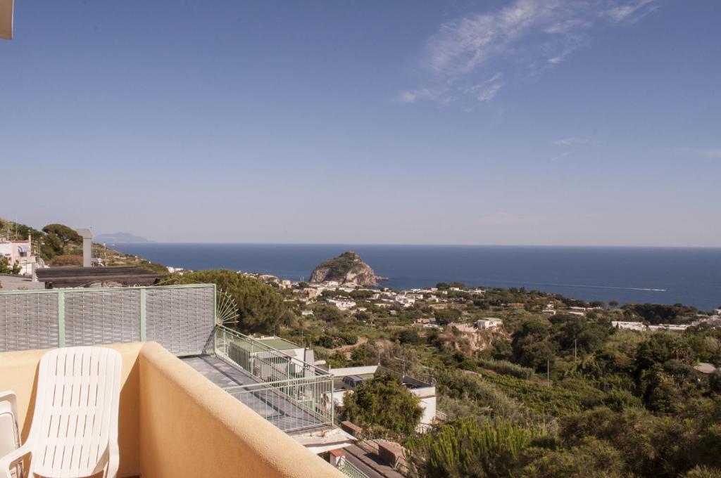 a balcony with two white chairs and the ocean at Hotel Polito in Ischia