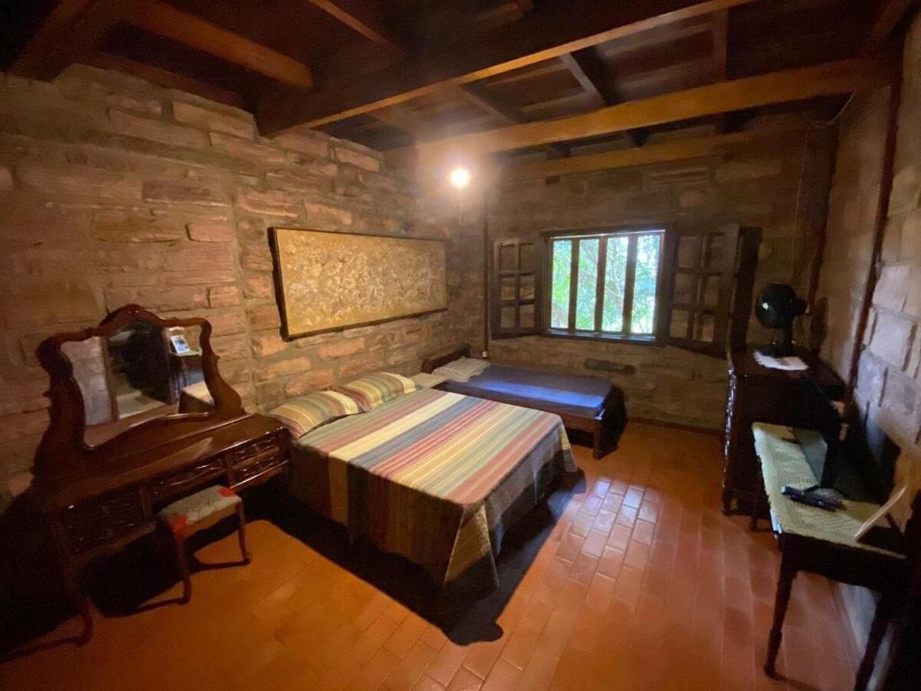 a bedroom with a bed and a piano in a room at Pousada Casa Fraternità, viva momentos de tranquilidade em contato com a natureza. in Andaraí