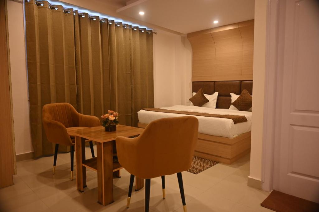Un dormitorio con una cama y una mesa y sillas. en Pine Ville Shimla, en Shimla