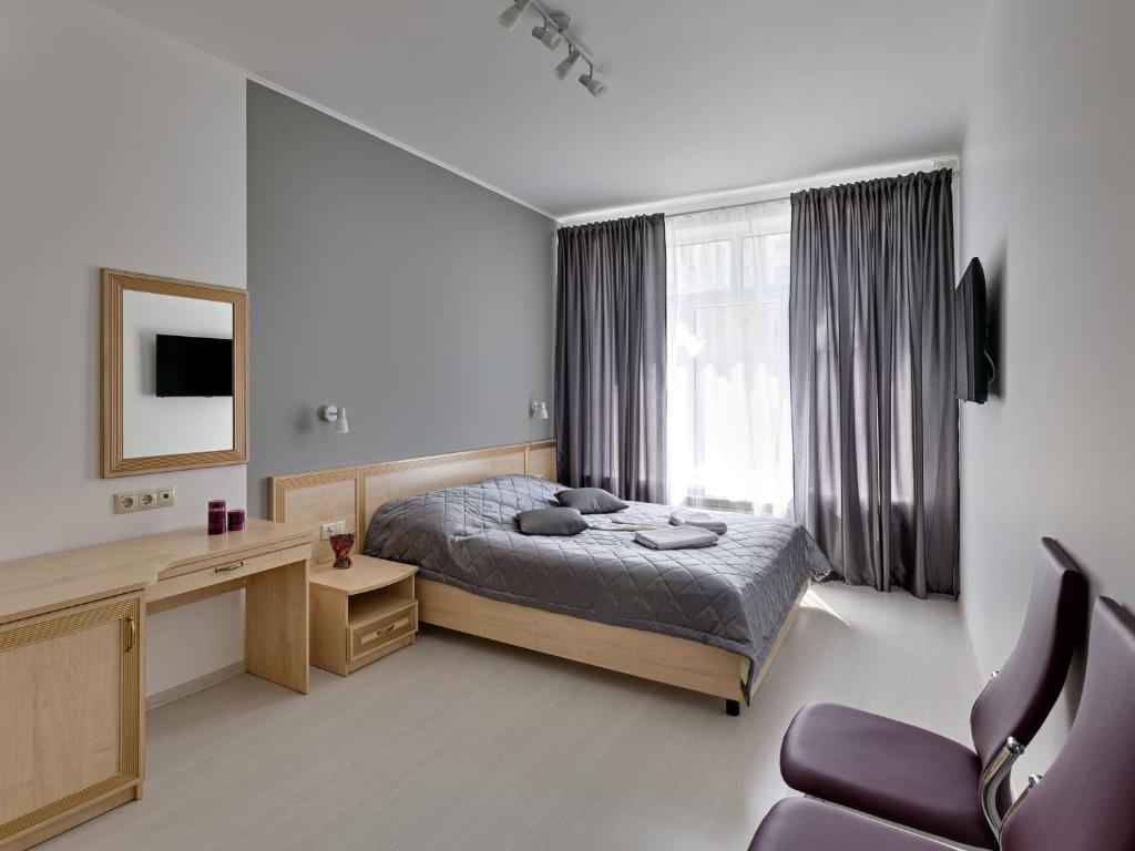 モスクワにあるMinima Vodny Hotelのベッドルーム1室(ベッド1台、デスク、椅子付)