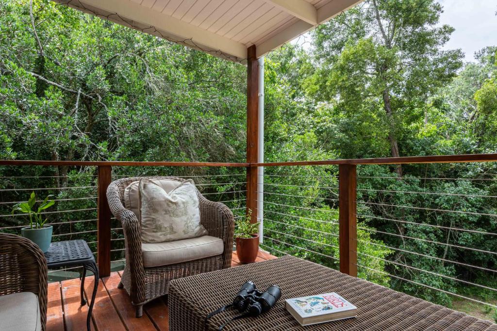 une véranda avec une table et une chaise sur une terrasse dans l'établissement Forest Glades, à Knysna