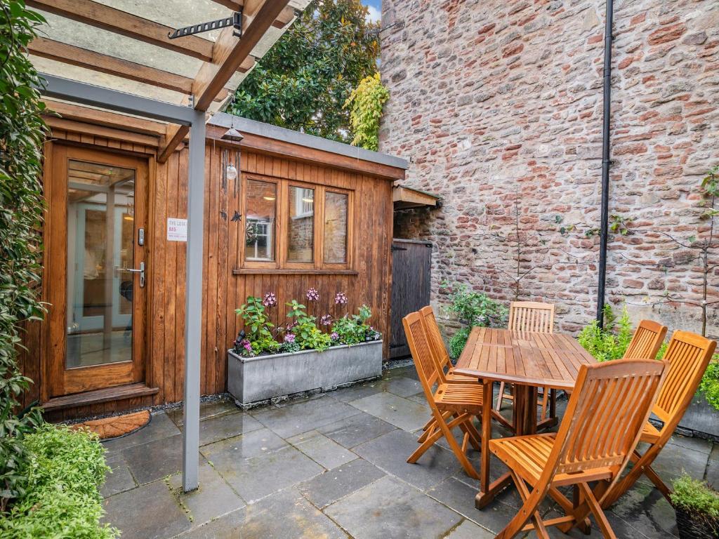 a patio with a wooden table and chairs at Rock House in Wells