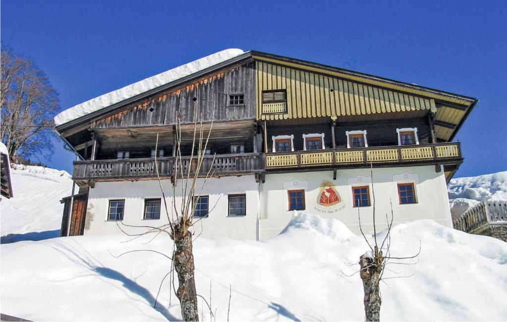 duży drewniany budynek w śniegu w obiekcie Ferienhaus In Maria Luggau w mieście Maria Luggau