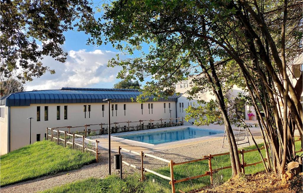 um edifício com uma piscina ao lado de uma árvore em Nice Apartment In Siena With Outdoor Swimming Pool em Siena