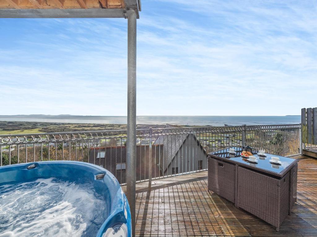 a hot tub on the deck of a house at Milkwood in Pendine
