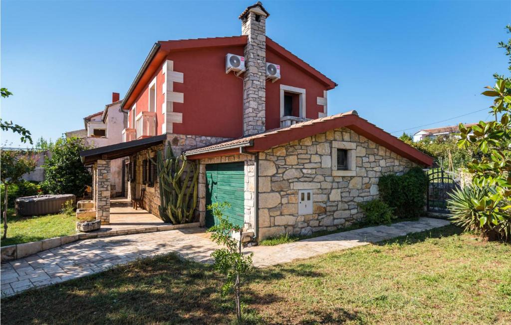 een huis met een groene garage ervoor bij Pet Friendly Home In Posedarje With Wifi in Posedarje