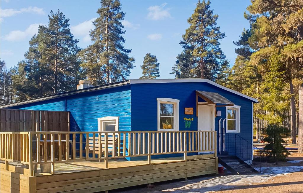 a blue tiny house with a wooden porch at 2 Bedroom Stunning Home In Grsmark in Gräsmark