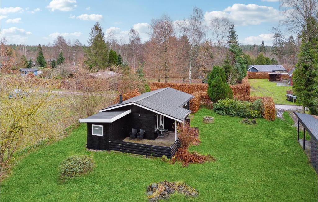 uma pequena casa preta num relvado verde em Amazing Home In Ebeltoft With Wifi em Ebeltoft
