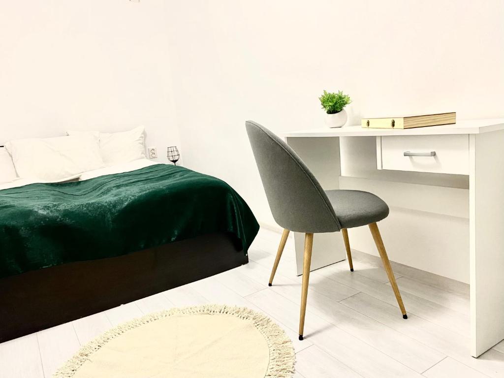 a bedroom with a bed and a desk and a chair at Apartament - Voineasa -Aproape de Domeniul Schiabil in Voineasa