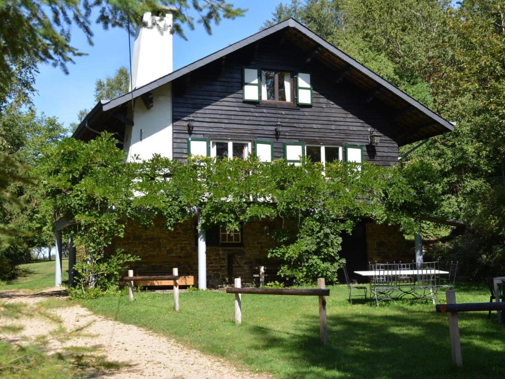 una casa negra con bancos delante en Luxury Pet friendly Chalet in Bi vre near Forest, en Bièvre