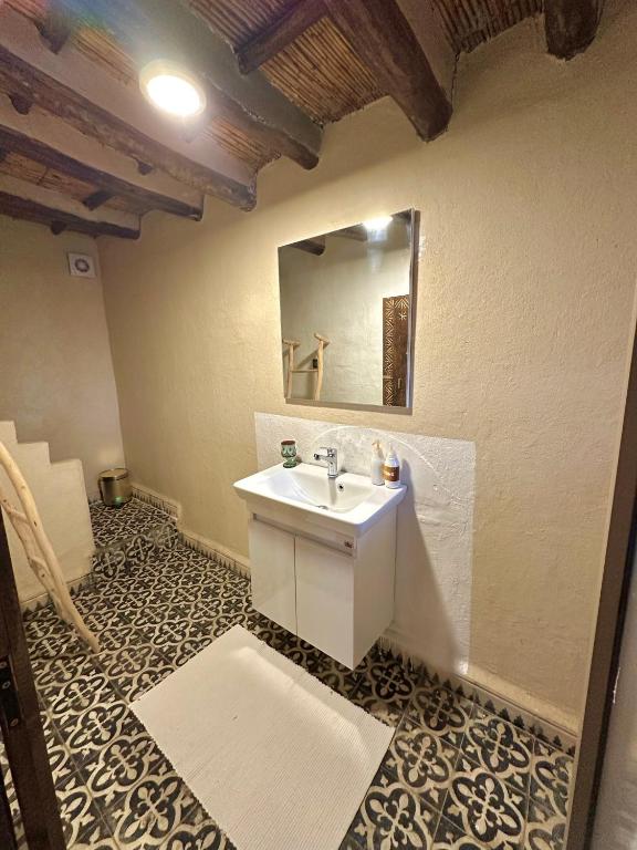 a bathroom with a sink and a mirror on the wall at Kasbah El Hajja in Aït Benhaddou