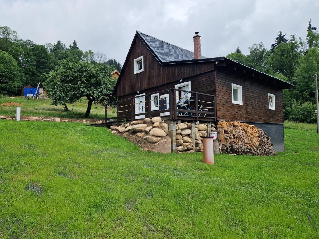 ein Haus mit einem Stapel Holz davor in der Unterkunft Chaty u lesa in Velké Hamry