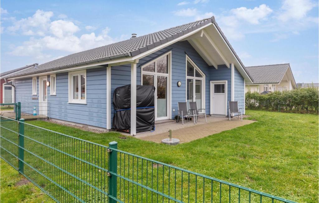 ein blaues Haus mit einem Zaun davor in der Unterkunft Nice Home In Dagebll With 2 Bedrooms, Sauna And Wifi in Dagebüll
