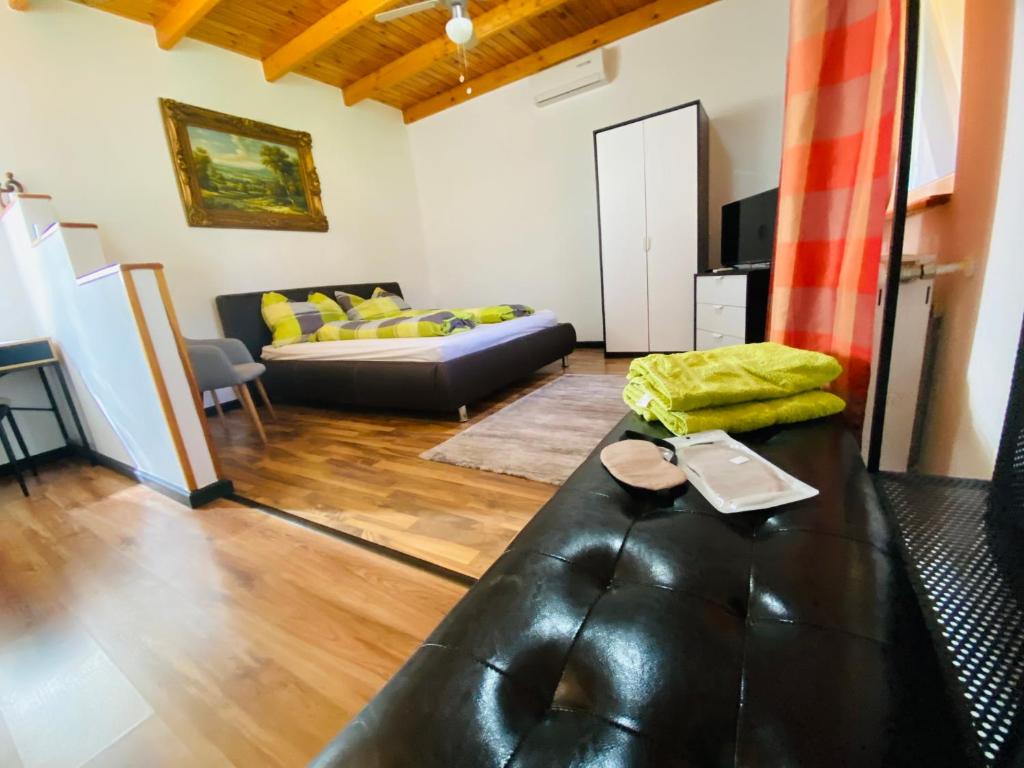 una sala de estar con un sofá de cuero negro en una habitación en Borostyán Apartmanház en Mórahalom