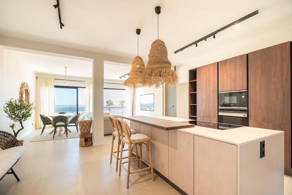 eine Küche mit einer Insel mit Stühlen und einem Tisch in der Unterkunft Luxury piso Nijota NEW in Santa Cruz de Tenerife