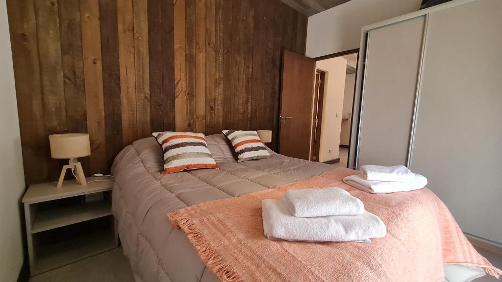 1 dormitorio con 1 cama grande y toallas. en Aluen PBA - Andarlibre en San Martín de los Andes