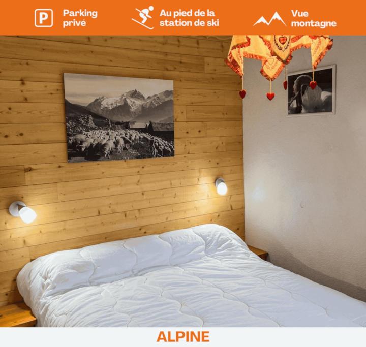 sypialnia z łóżkiem z drewnianą ścianą w obiekcie T1 Cosy Pleine station de ski w mieście Bellevaux