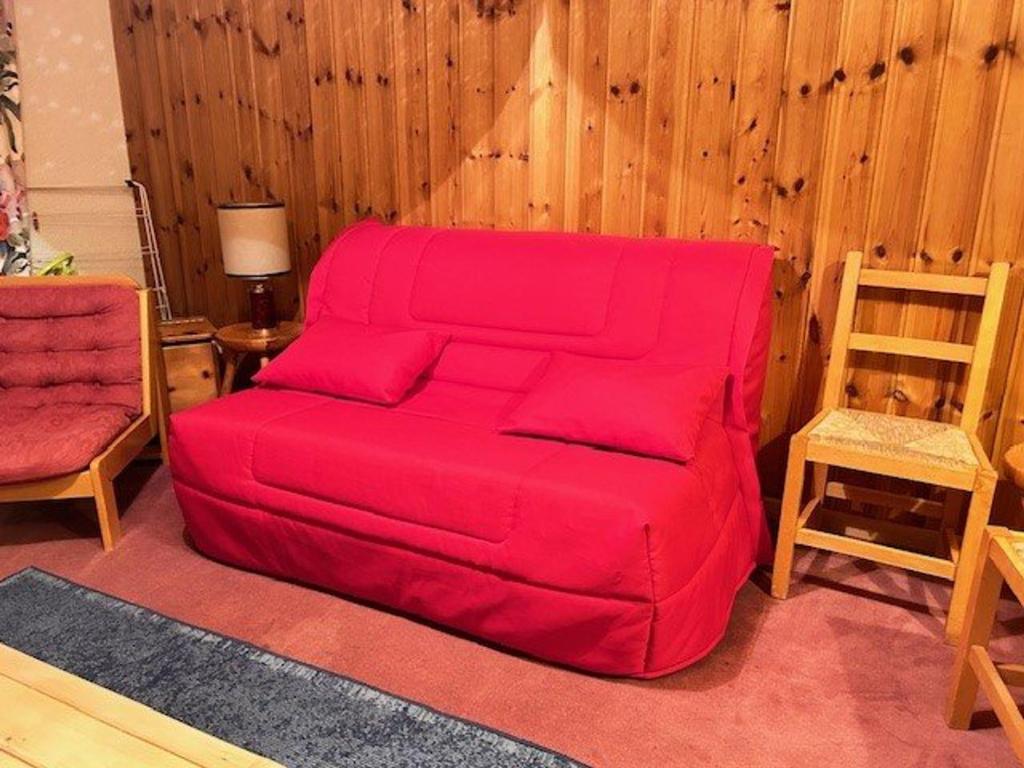 a red couch in a living room with a chair at Appartement Risoul, 2 pièces, 6 personnes - FR-1-330-495 in Risoul