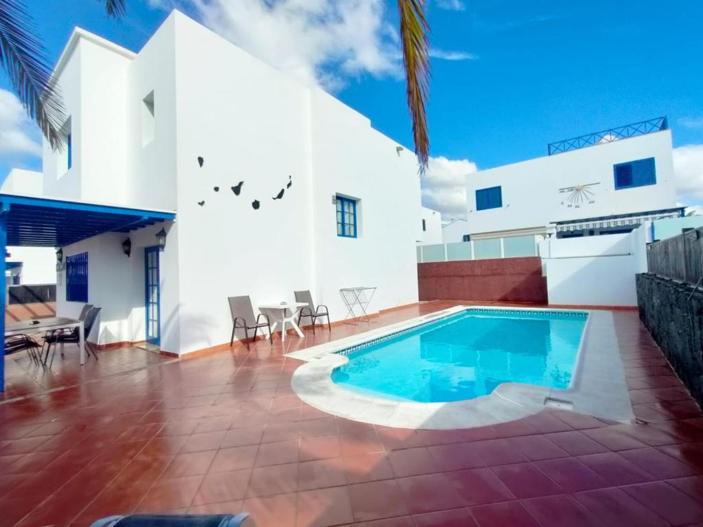 a swimming pool in the backyard of a house at Villa Rubicón Costa in Playa Blanca