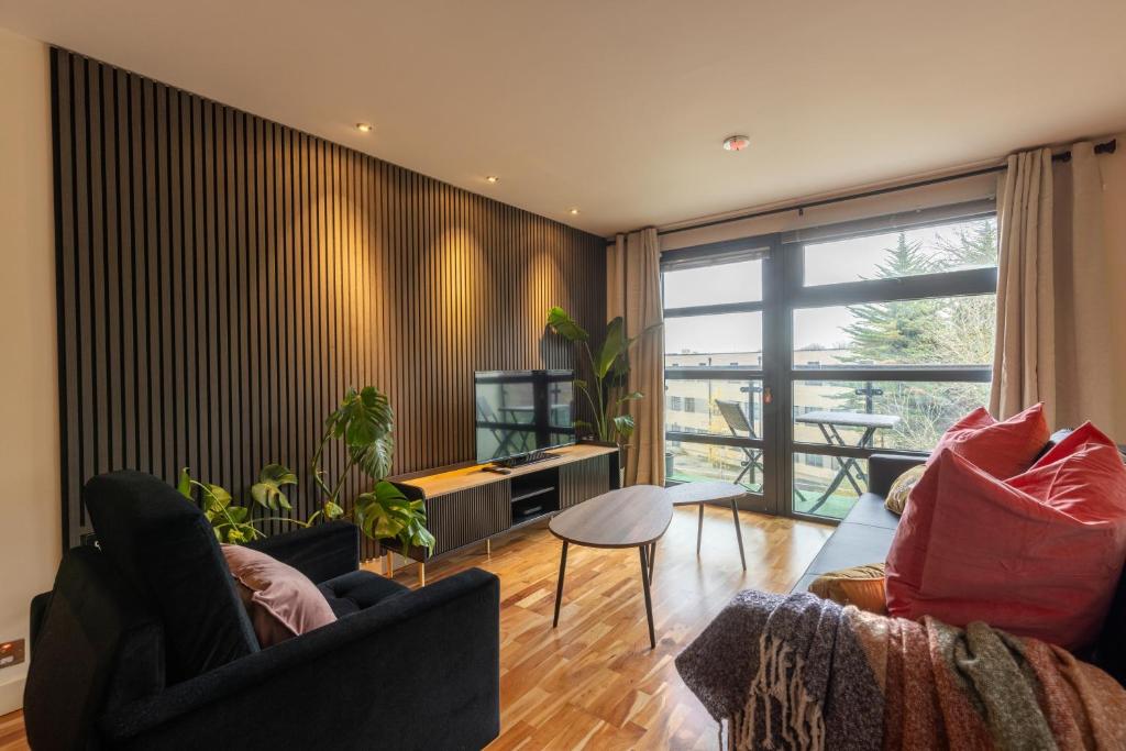 ein Wohnzimmer mit 2 Stühlen und einem TV in der Unterkunft Durham City Luxury Apartment in Durham