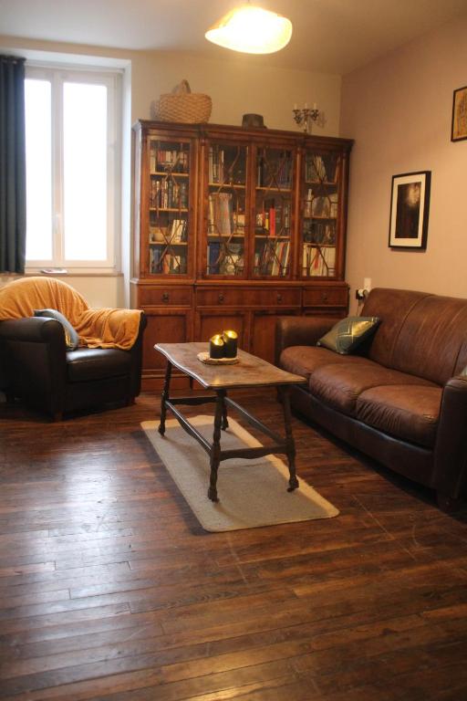 ein Wohnzimmer mit einem Sofa und einem Couchtisch in der Unterkunft Gîte du Chat noir (Brocéliande) in Campénéac
