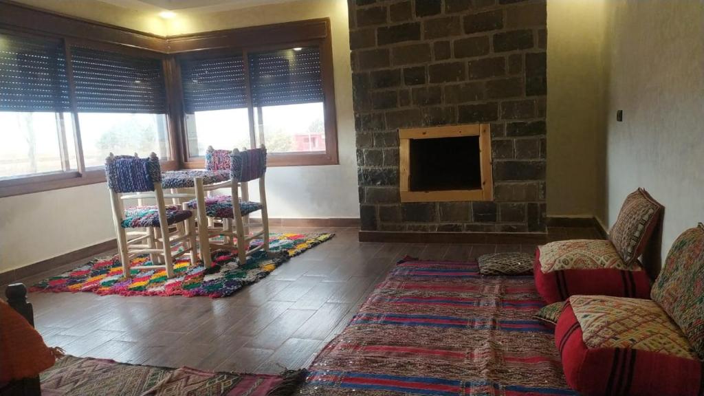 a living room with chairs and a stone fireplace at Chez karim in Ifrane