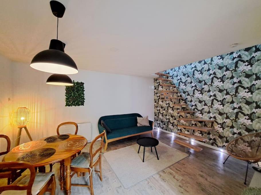a living room with a dining room table and a wall of cows at Santorin, duplex chaleureux in Reims