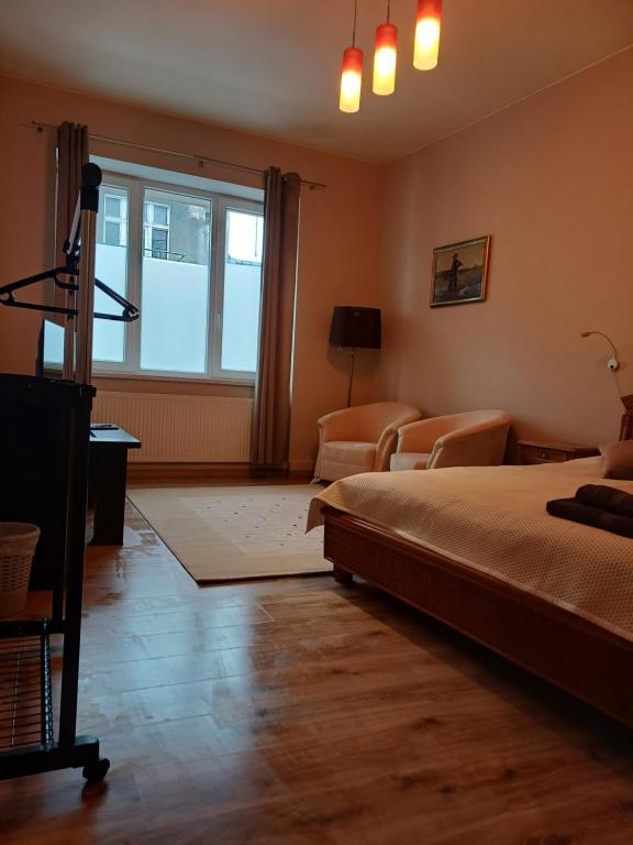 - une chambre avec un lit, un canapé et une fenêtre dans l'établissement OMMP CENTRUM, à Częstochowa