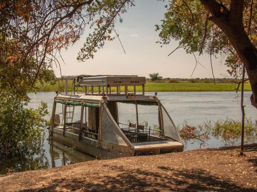 un barco sentado en el agua en un río en Zambezi King Fisher Lodge, en Katima Mulilo