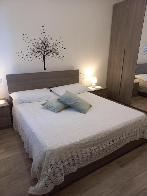 een slaapkamer met een bed met een boom aan de muur bij la casa di Carla in Pescara