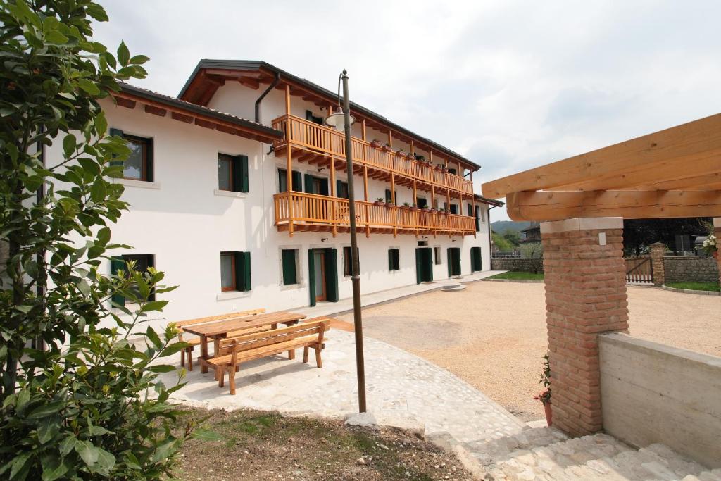 un bâtiment avec un banc en bois devant lui dans l'établissement Albergo Diffuso Polcenigo C. Zoldan, à Polcenigo