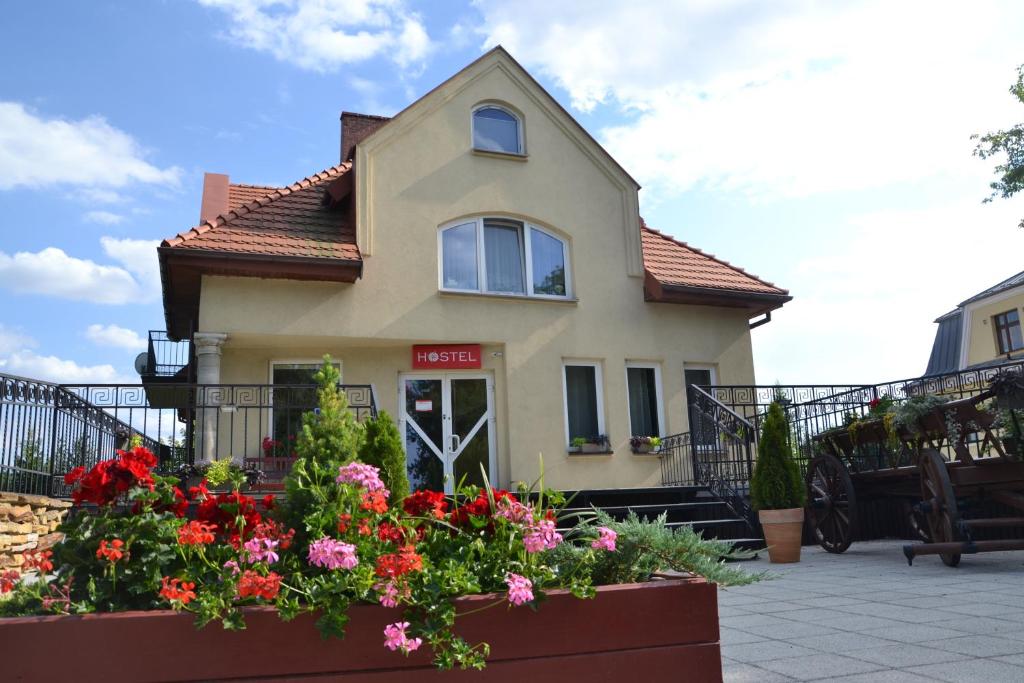 une maison avec des fleurs devant elle dans l'établissement Hostel Zamość, à Zamość