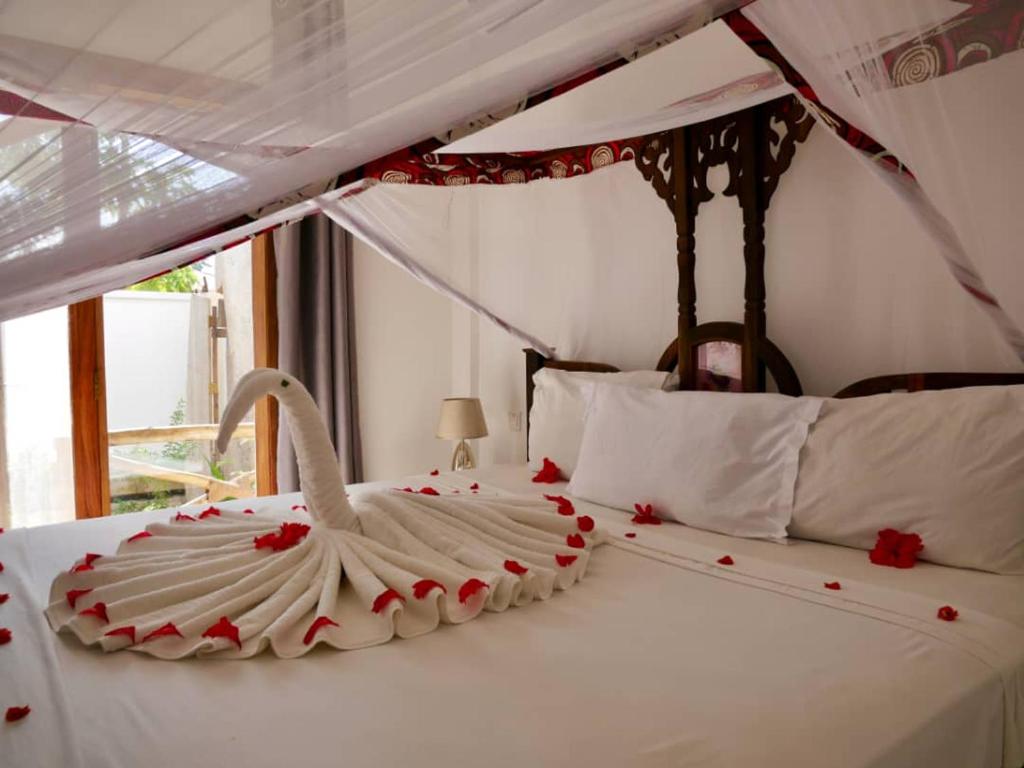 a bedroom with a white bed with a swan on it at Nungwi ocean view in Nungwi