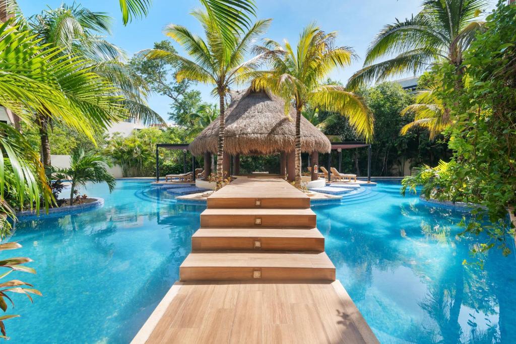 un complejo con una piscina con palmeras y un camino en Luxurious Penthouse with Jungle View & Private Pool en Tulum