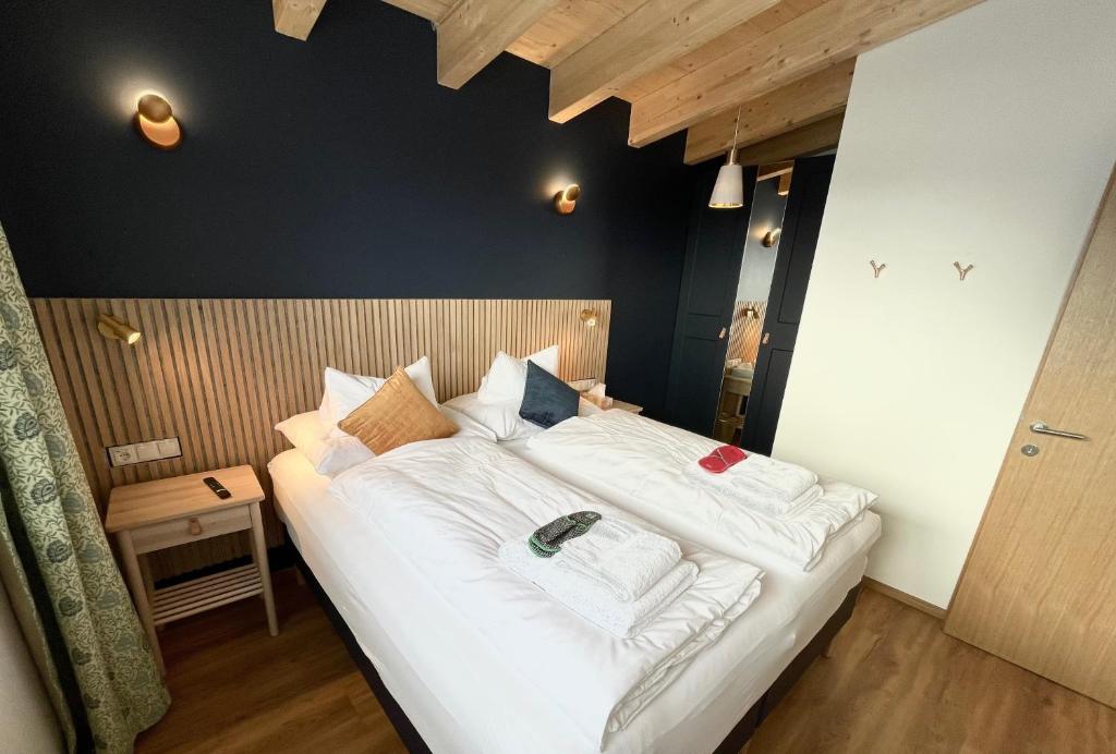 1 dormitorio con 1 cama grande con sábanas blancas en Apart 7 Stuben en Stuben am Arlberg