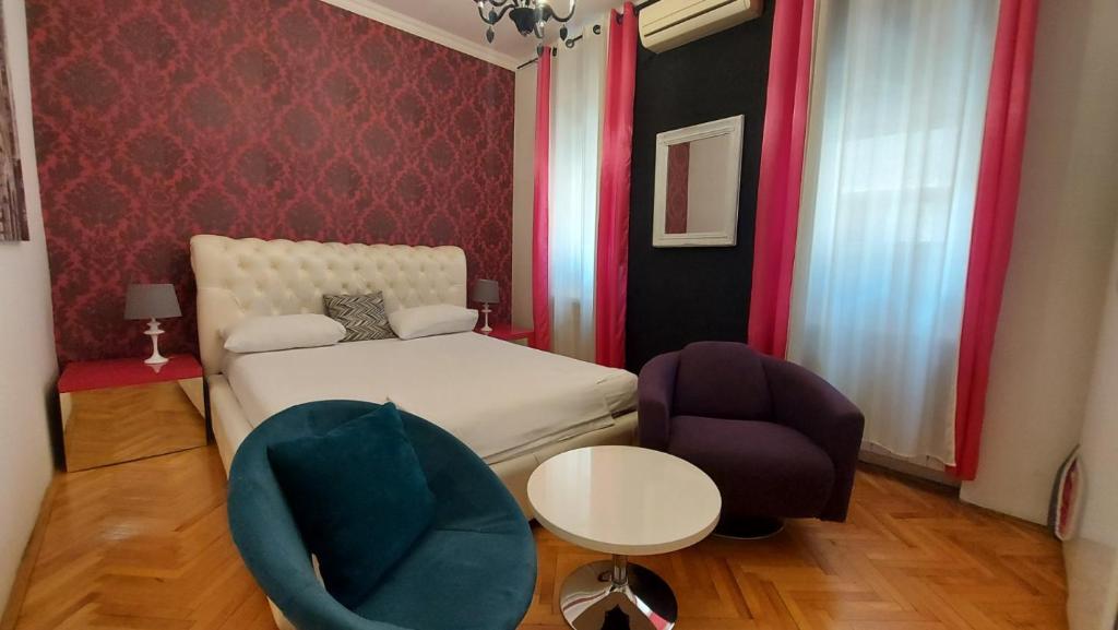 Un pequeño dormitorio con una cama y una silla. en TITO, en Belgrado
